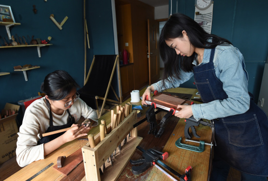 5月5日,南京林业大学家居与工业设计学院的大四学生吴乐(右)和韩艺在工作室制作木艺品, 新华社记者孙参摄 